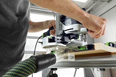 Person using a Festool router with dust extraction on a guide rail for precise woodworking tool operation in home improvement tasks