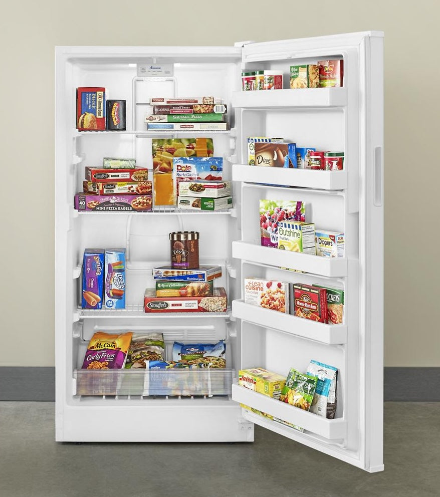 White upright freezer with multiple wire shelves and door bins stocked with frozen foods in Appliances and Kitchenware collections