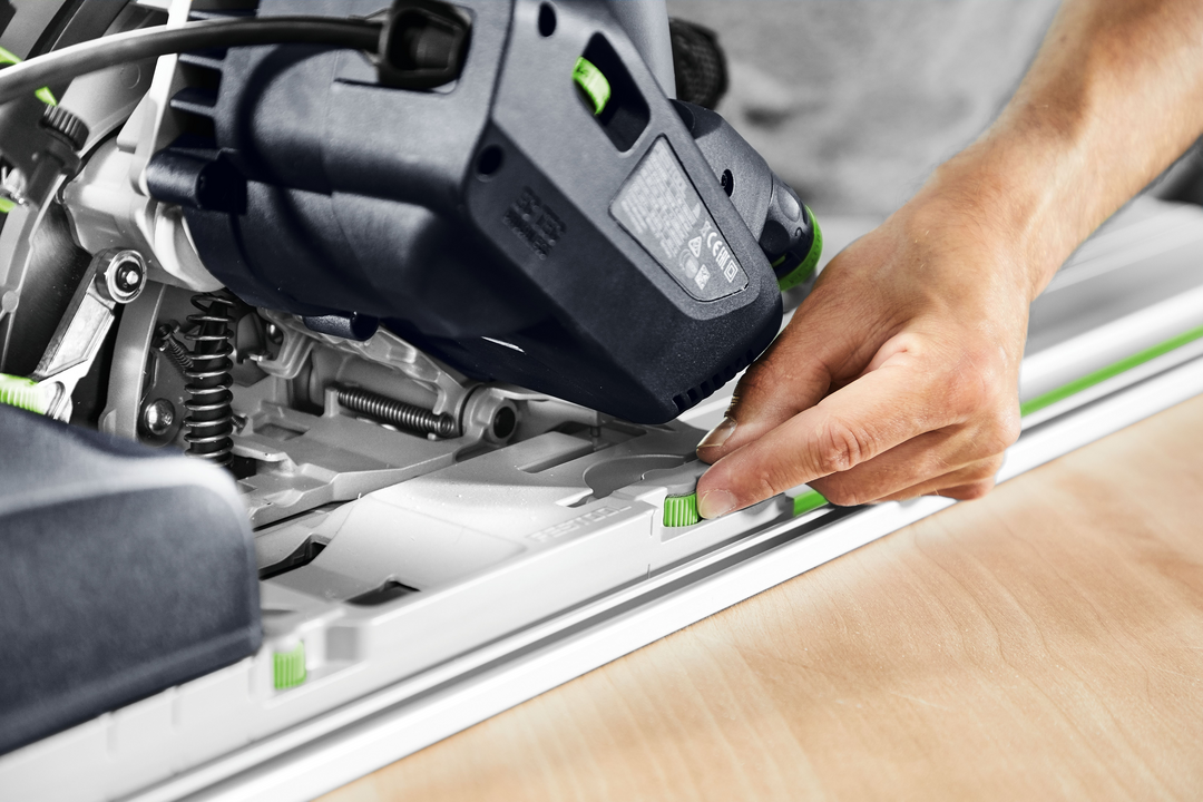 Hand adjusting green lever on blue and white Festool plunge cut track saw in power tools and home improvement collections
