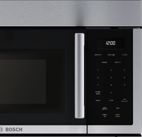 Close-up of stainless steel over-the-range microwave with left side door opening and digital control panel in kitchen appliances collection