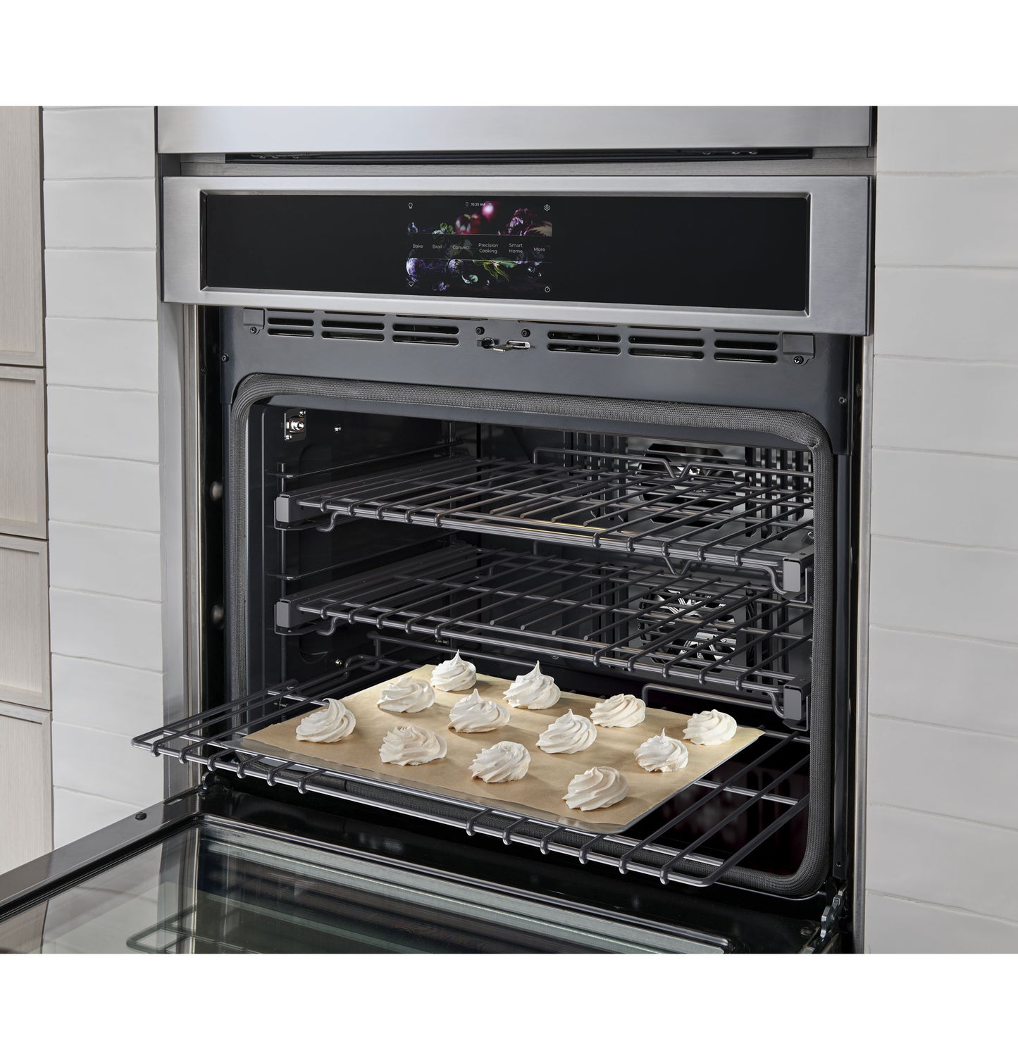 Open stainless steel statement wall oven with baking tray of meringue cookies inside from kitchen appliances collection