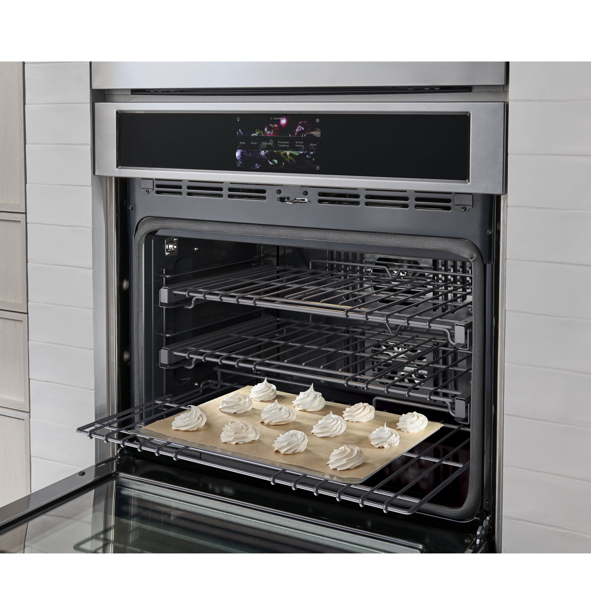 Open stainless steel statement wall oven with baking tray of meringue cookies inside from kitchen appliances collection
