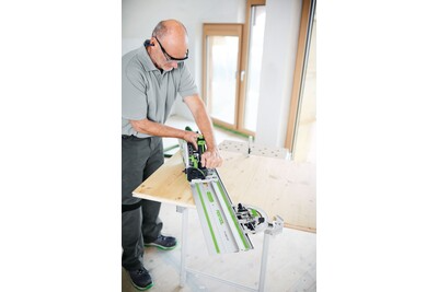 Professional using a Festool guide rail with a circular saw on a wooden board for precise home improvement tasks