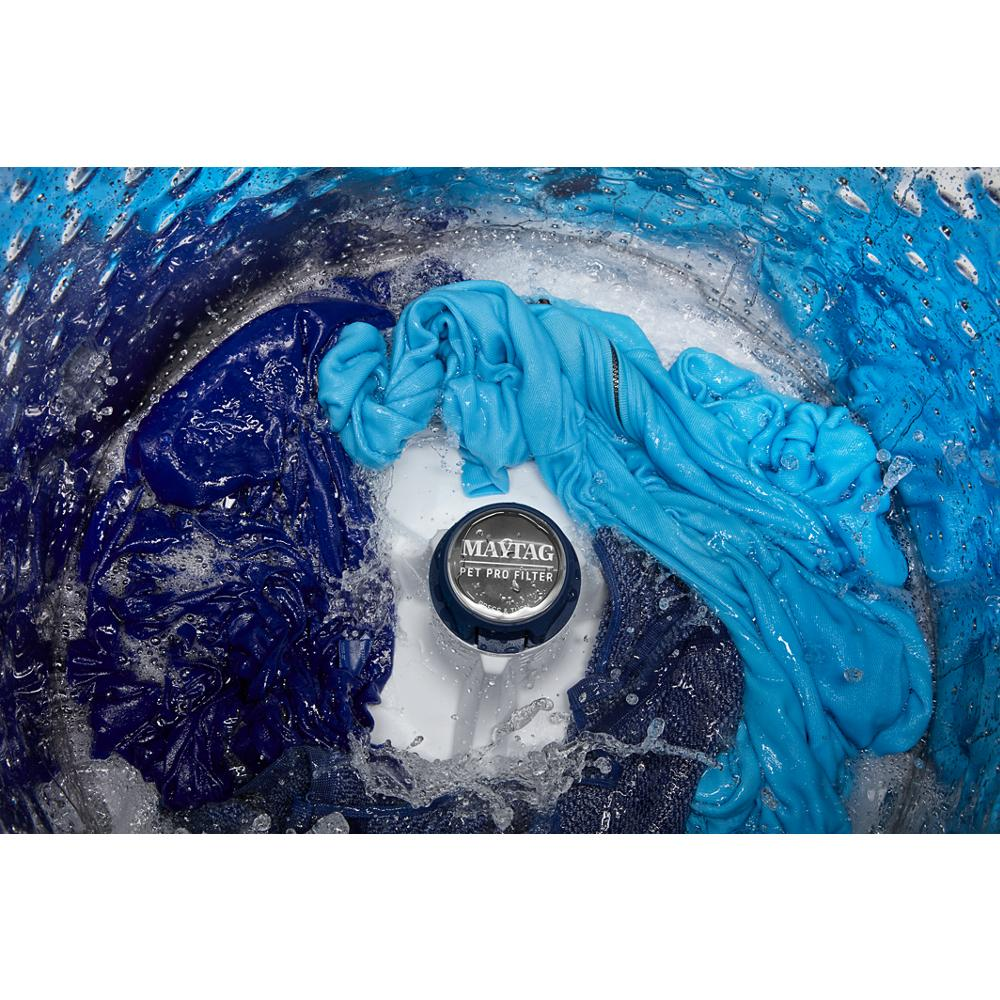 Inside view of top load washer with clothes and water swirling around the impeller for thorough cleaning and pet hair removal