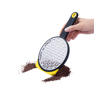 Hand holding yellow and black medium-sized grater with ergonomic handle for kitchen gadgets under $50 collections