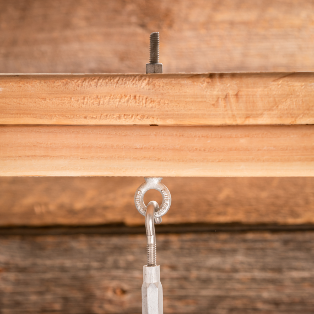Galvanized eye bolt with shoulder installed in wood beam for secure fastening in hardware and home improvement tools under 50