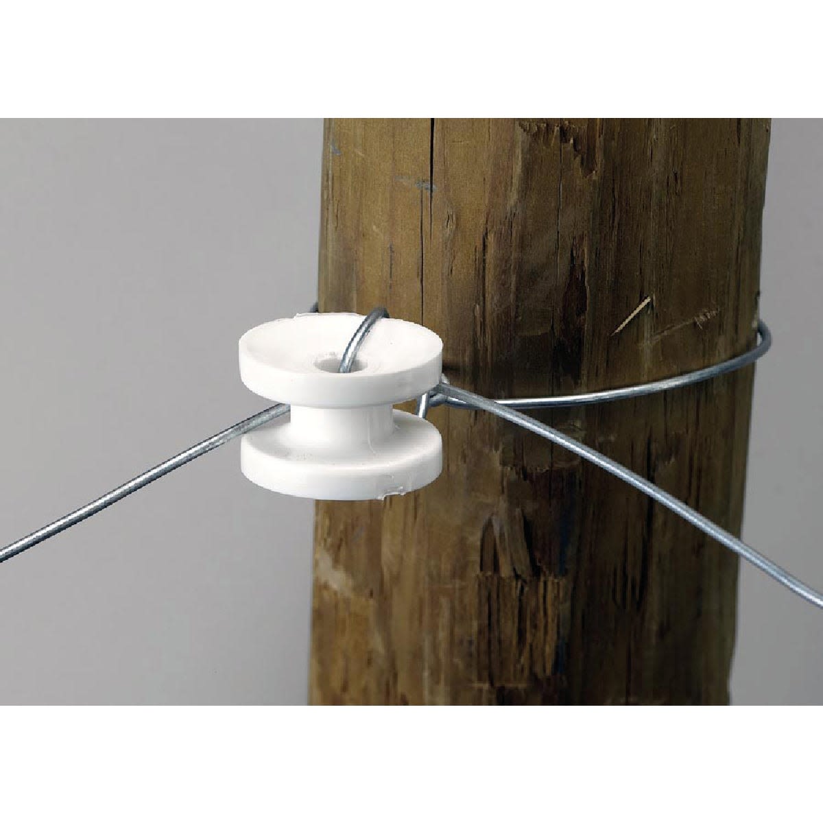 White poly corner insulator attached to wood post securing twisted metal wire for home improvement projects