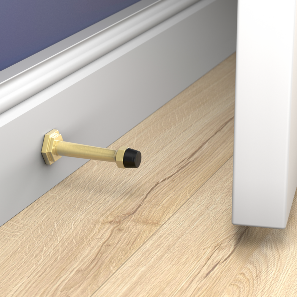 Brushed gold wall-mounted door stop with black rubber tip protecting wall and molding in door accessories and home improvement collections