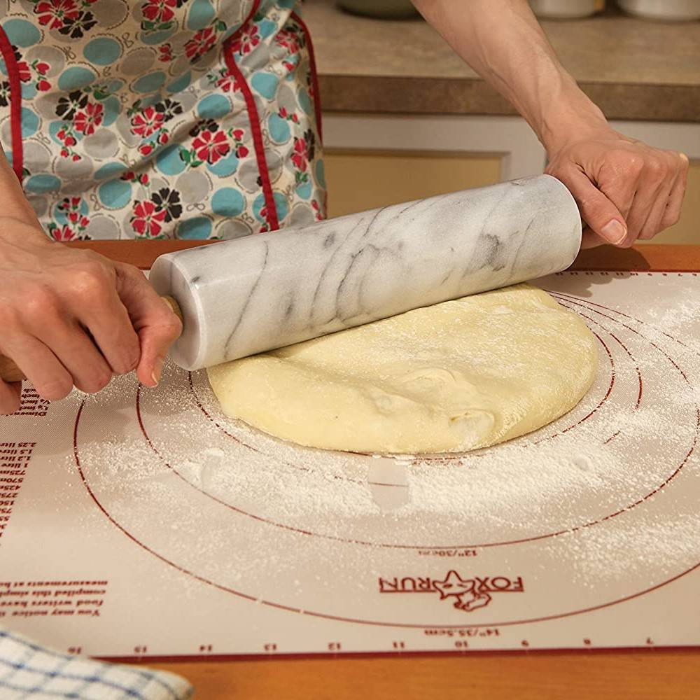 Hands rolling dough with gray marble rolling pin on silicone baking mat in Kitchenware and Bakeware collections