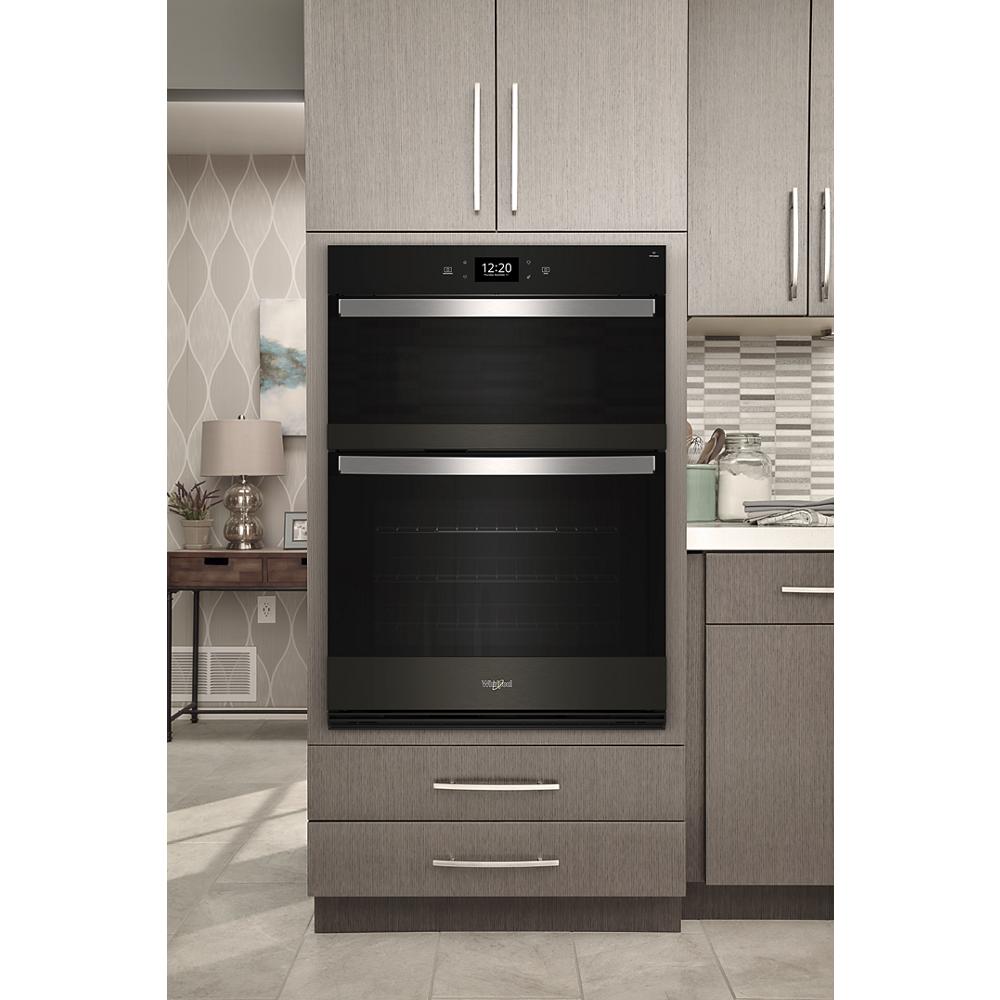 Built-in black Whirlpool wall oven with stainless steel handles in modern kitchen cabinetry in Wall Ovens collection