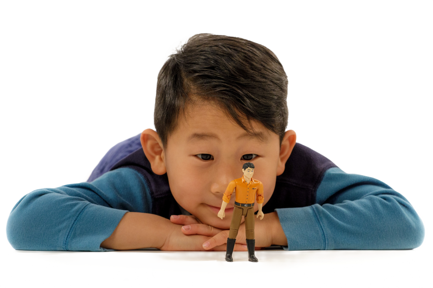 Young boy in blue shirt watching Bruder 60007 male figurine for imaginative tools and home improvement play