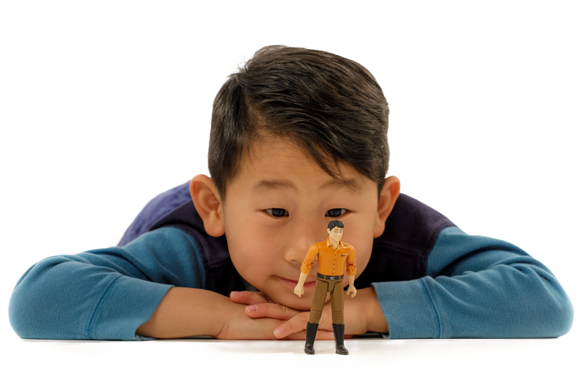 Young boy in blue shirt watching Bruder 60007 male figurine for imaginative tools and home improvement play