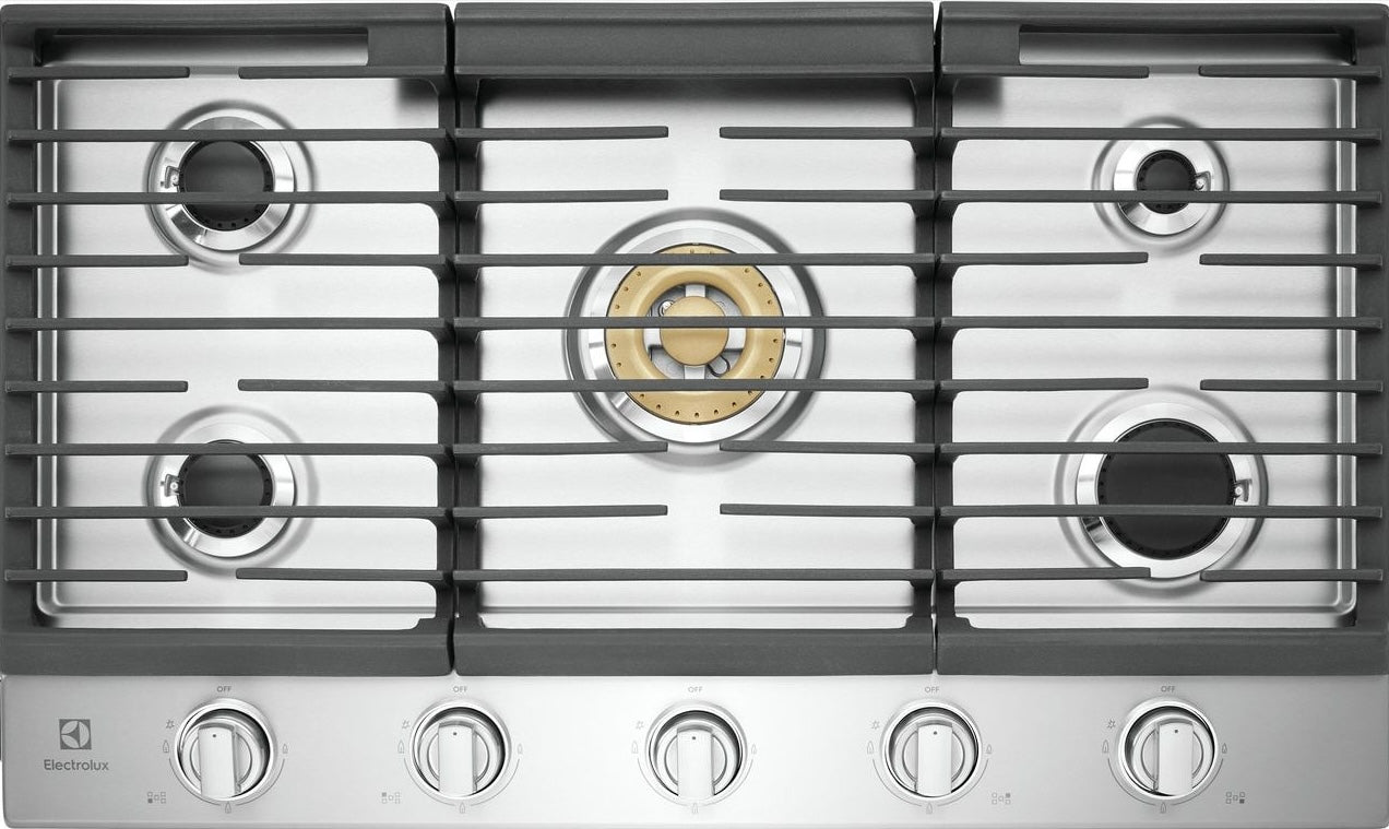 Top view of a stainless steel cooktop featuring five burners with brass and black accents and front control knobs for home improvement.
