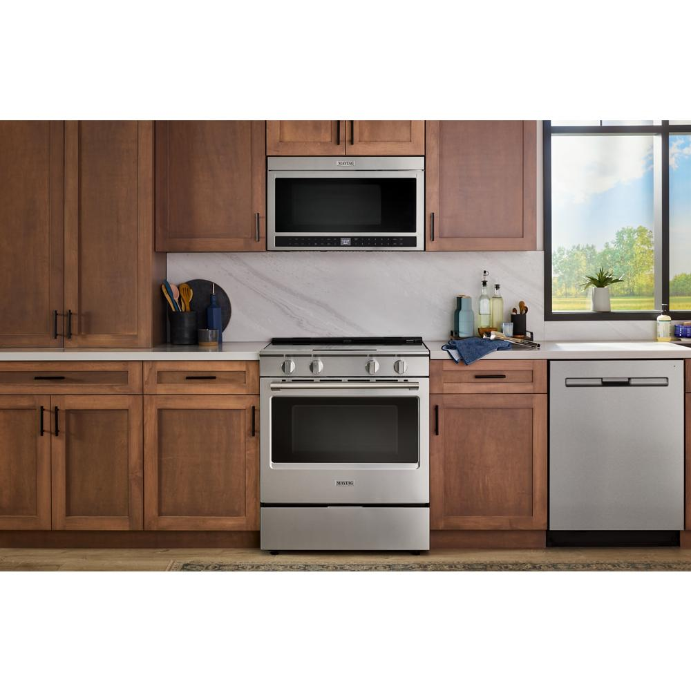 Modern stainless steel slide-in electric range with grill mode and no preheat air fry in wood kitchen cabinetry setting