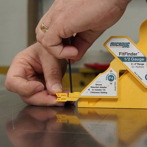 Hand adjusting yellow Microjig gauge tool on metal surface, part of power tool and saw accessories under $50 collection