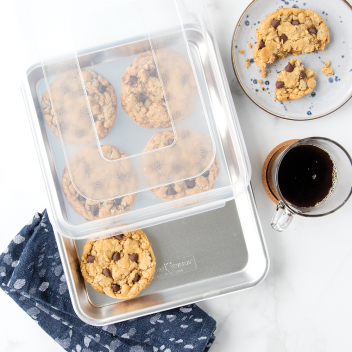 Natural aluminum quarter sheet pan with clear lid, filled with chocolate chip cookies, part of kitchenware under $50 collection