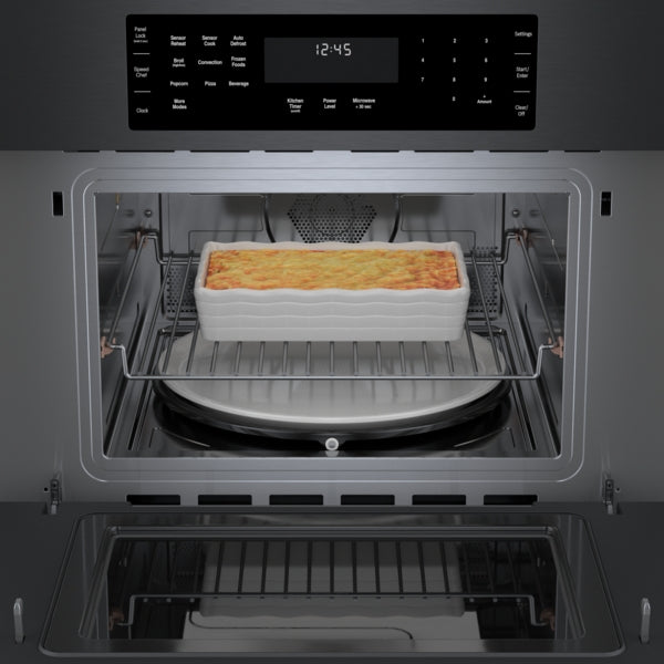 Black stainless steel speed oven from Bosch cooking casserole dish with digital control panel in modern kitchen setting