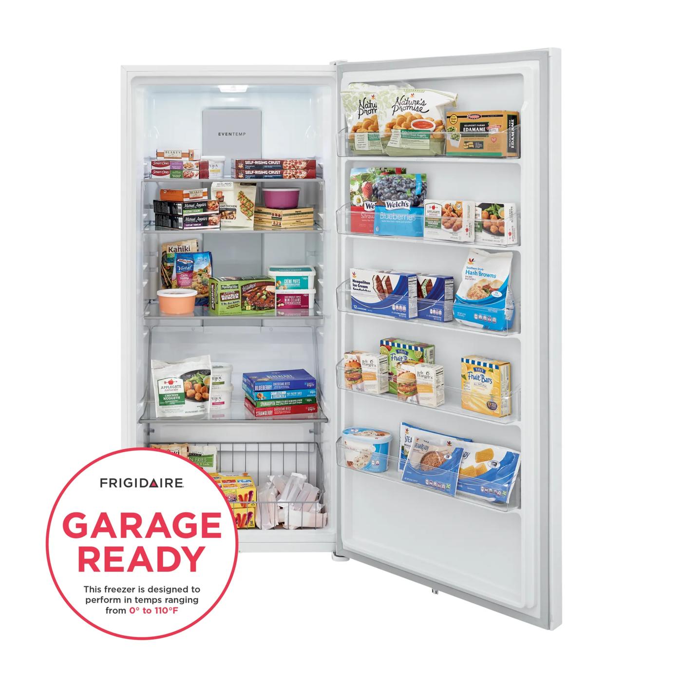 White upright freezer with multiple shelves and door bins stocked with frozen food in a home appliance setting
