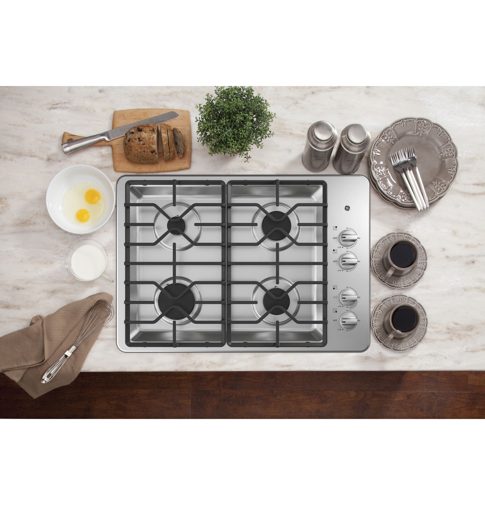 Stainless steel built-in gas cooktop with four burners and dishwasher-safe grates in a kitchen setting from Cooktops collection