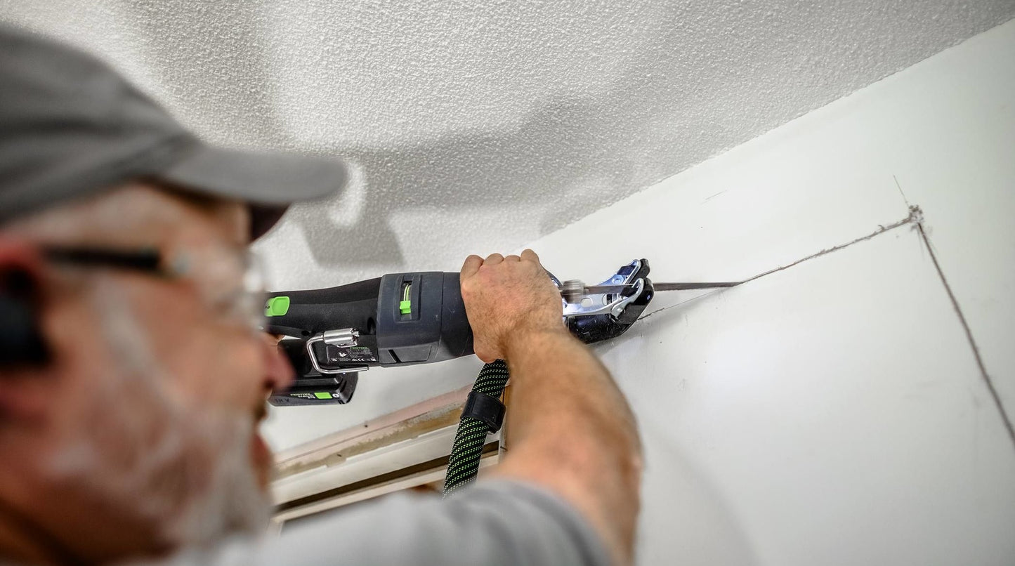 Person using cordless reciprocating saw from Festool cordless tools collection to cut drywall in home improvement project