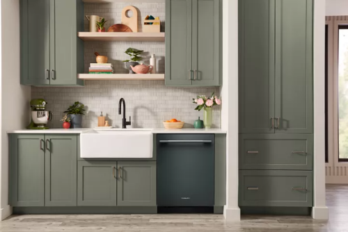 Matte dark green KitchenAid dishwasher with towel bar handle in modern kitchen featuring green cabinetry and farmhouse sink