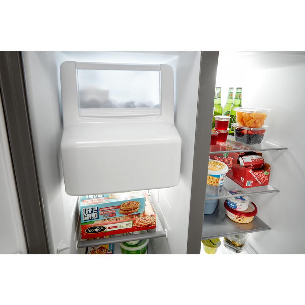 Interior view of a side-by-side refrigerator with shelves holding packaged food, beverages, and fresh fruit bowls in Appliances collection
