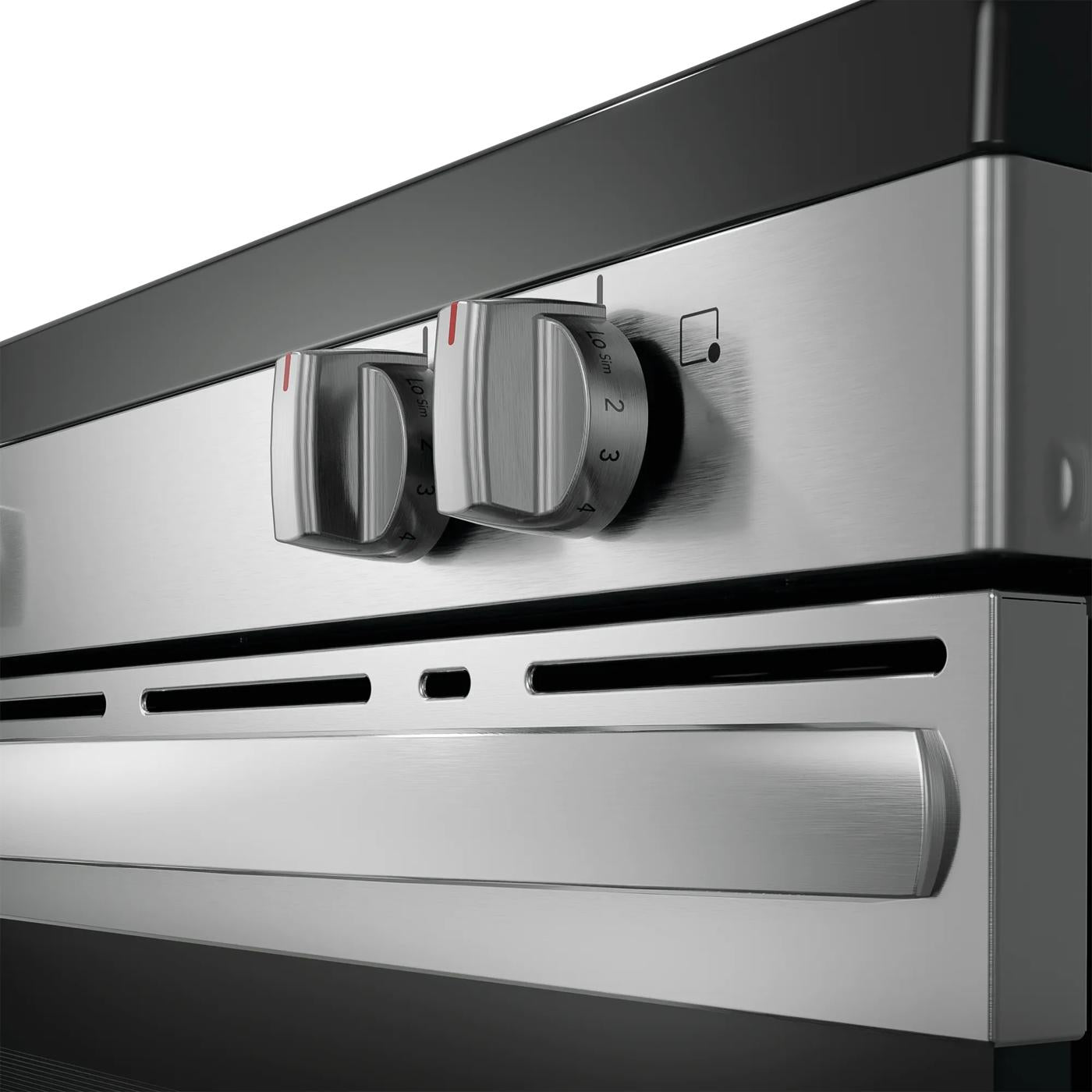 Close-up of stainless steel electric range control knobs and handle for kitchen appliances and home improvement collections