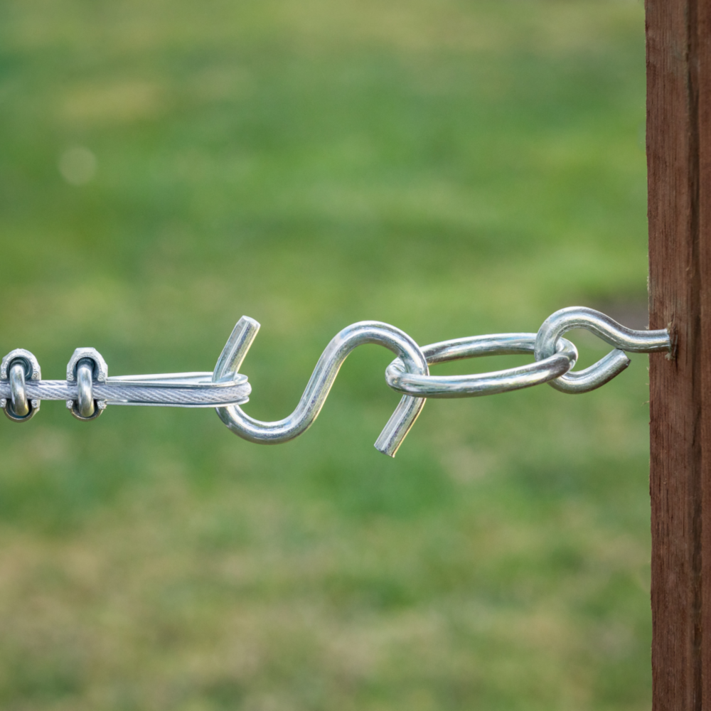 Zinc heavy-duty open S hook securing metal chain to wooden post for outdoor hardware and fasteners use