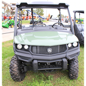 Full-size utility vehicle with rugged tires and sturdy roof, parked outdoors on grassy ground.