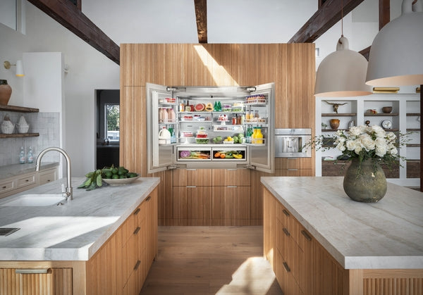 Built-in French door refrigerator with bottom freezer integrated into wood-paneled kitchen for home improvement use
