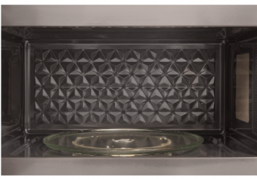 Interior view of a stainless steel microwave cavity with textured back panel and glass turntable from Microwaves collection