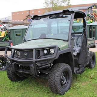 Green all-terrain crossover utility vehicle with rugged front brush guard and large off-road tires outdoors.