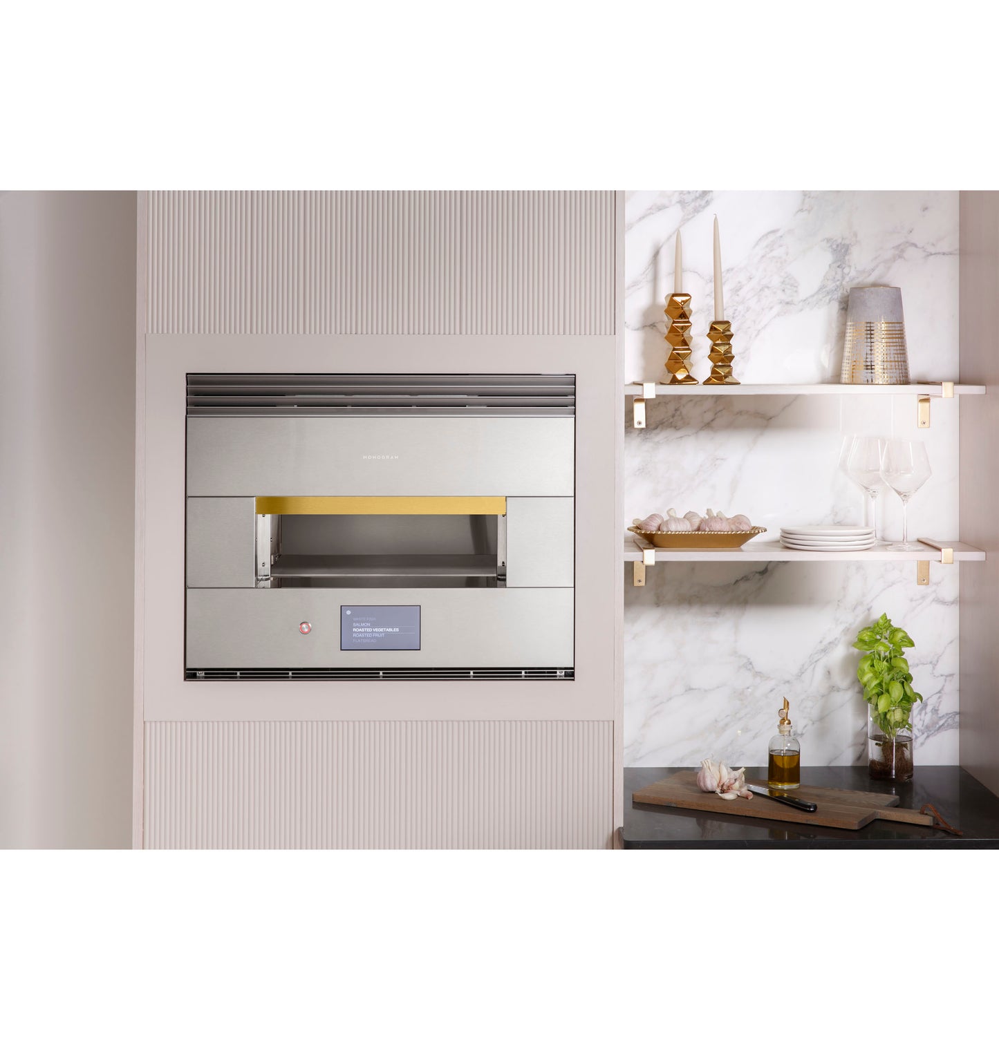 Built-in stainless steel hearth oven installed in modern kitchen with marble walls and floating shelves displaying kitchenware