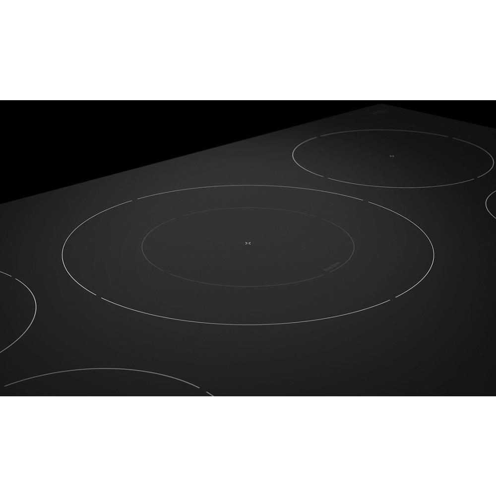 Close-up of sleek black induction cooktop with five sensor-controlled elements from modern KitchenAid appliances collection