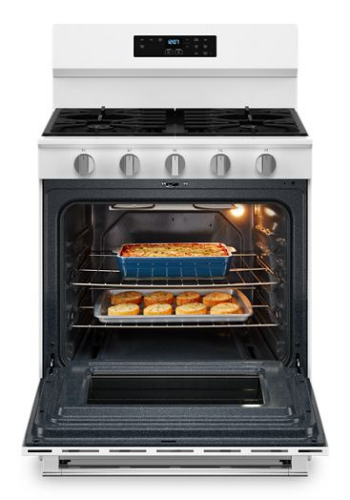 White 30-inch gas range with five burners, digital touch controls, and oven door open to show baked food inside