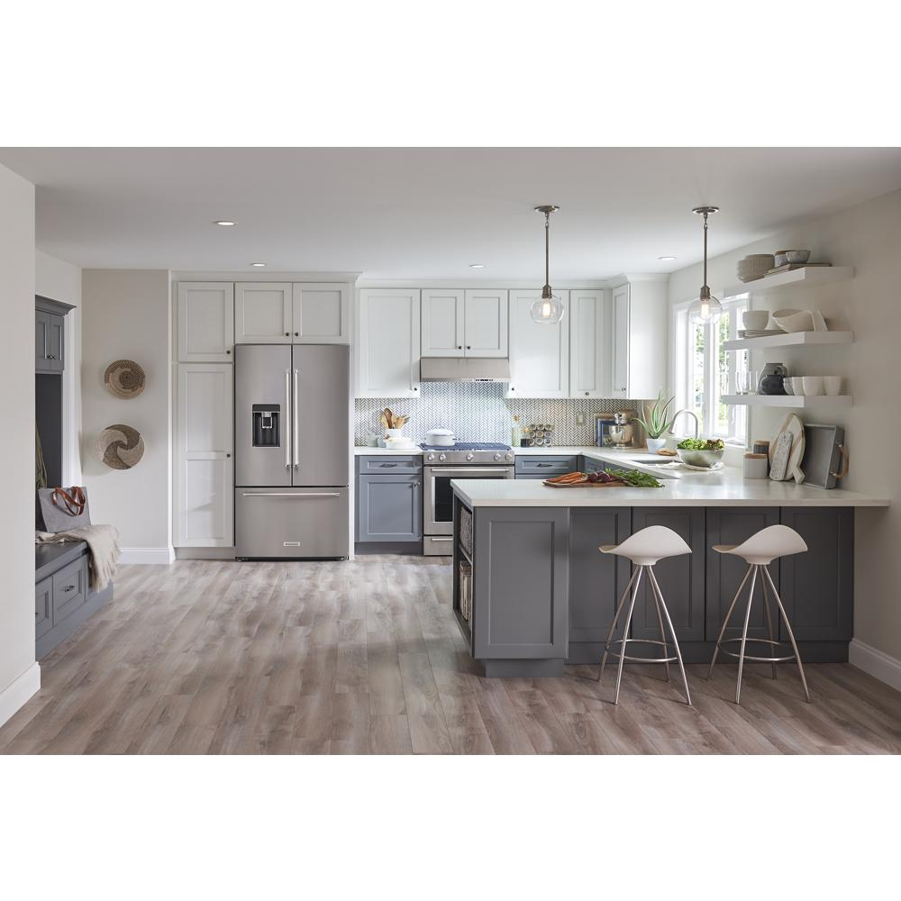 Modern kitchen with neutral cabinetry, island seating, stainless steel appliances, and bright natural lighting.