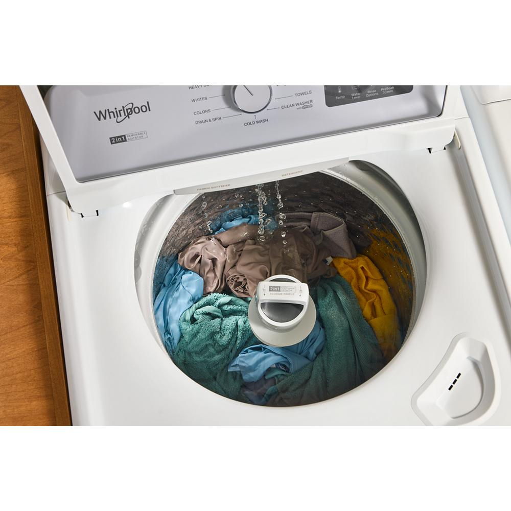Top load washer filling with water over mixed colored laundry and central 2-in-1 removable agitator in home laundry setting
