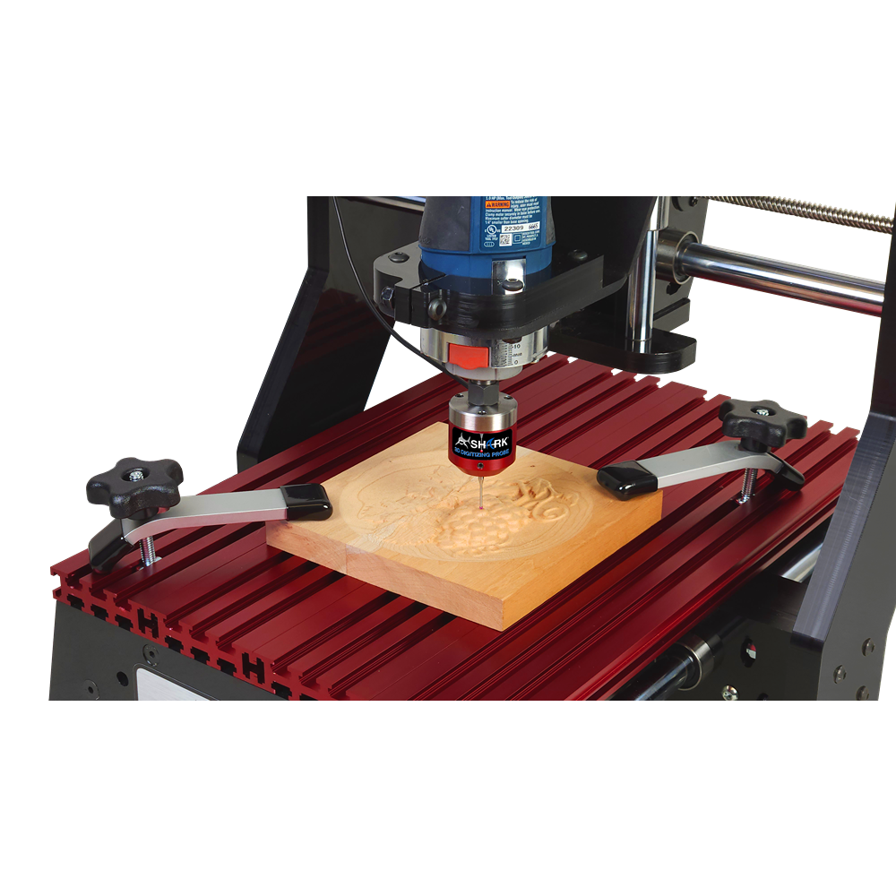 Close-up of CNC router with red digitizing probe tracing detailed wood carving on a compact workstation table