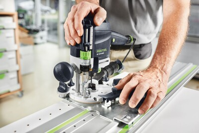 Hands operating a Festool router on a guide rail for woodworking tools and power tool accessories collections