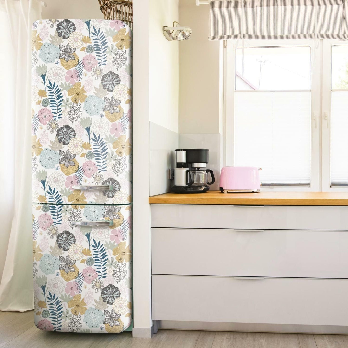 Floral patterned peel and stick wallpaper covering a refrigerator in a bright kitchen setting for home improvement.