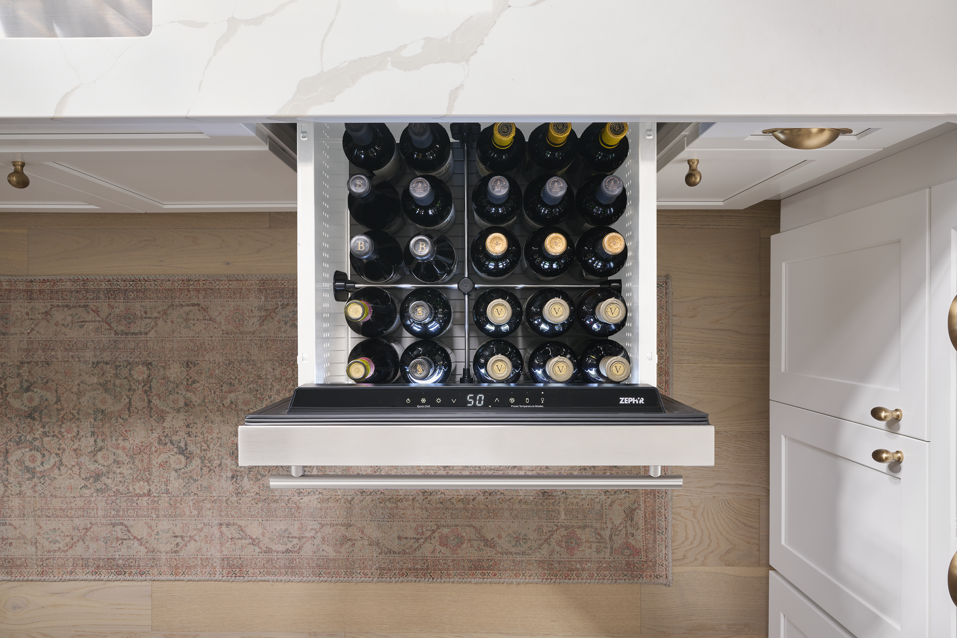 Under-counter stainless steel refrigerator drawer storing wine bottles with digital temperature control in modern kitchen design
