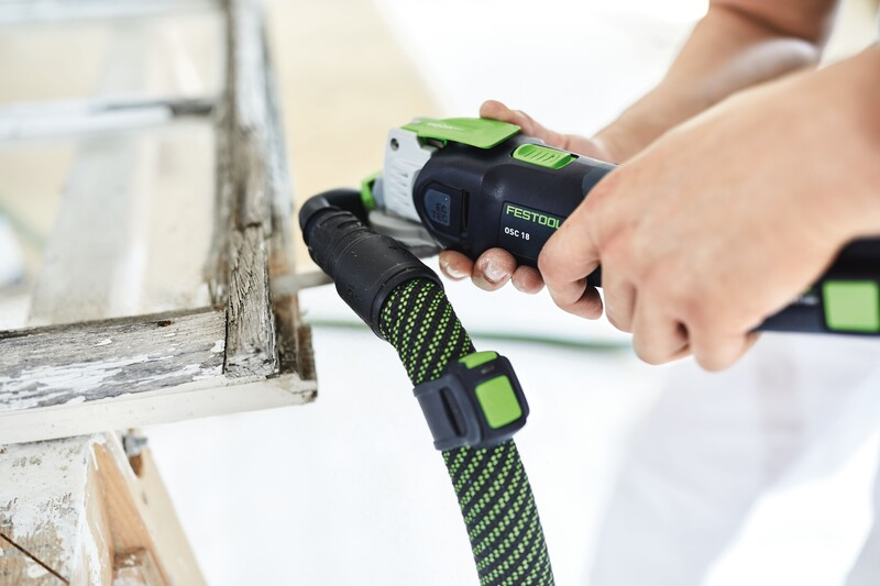 Person attaching hose to Festool dust extraction device for home improvement woodworking cleanup tasks