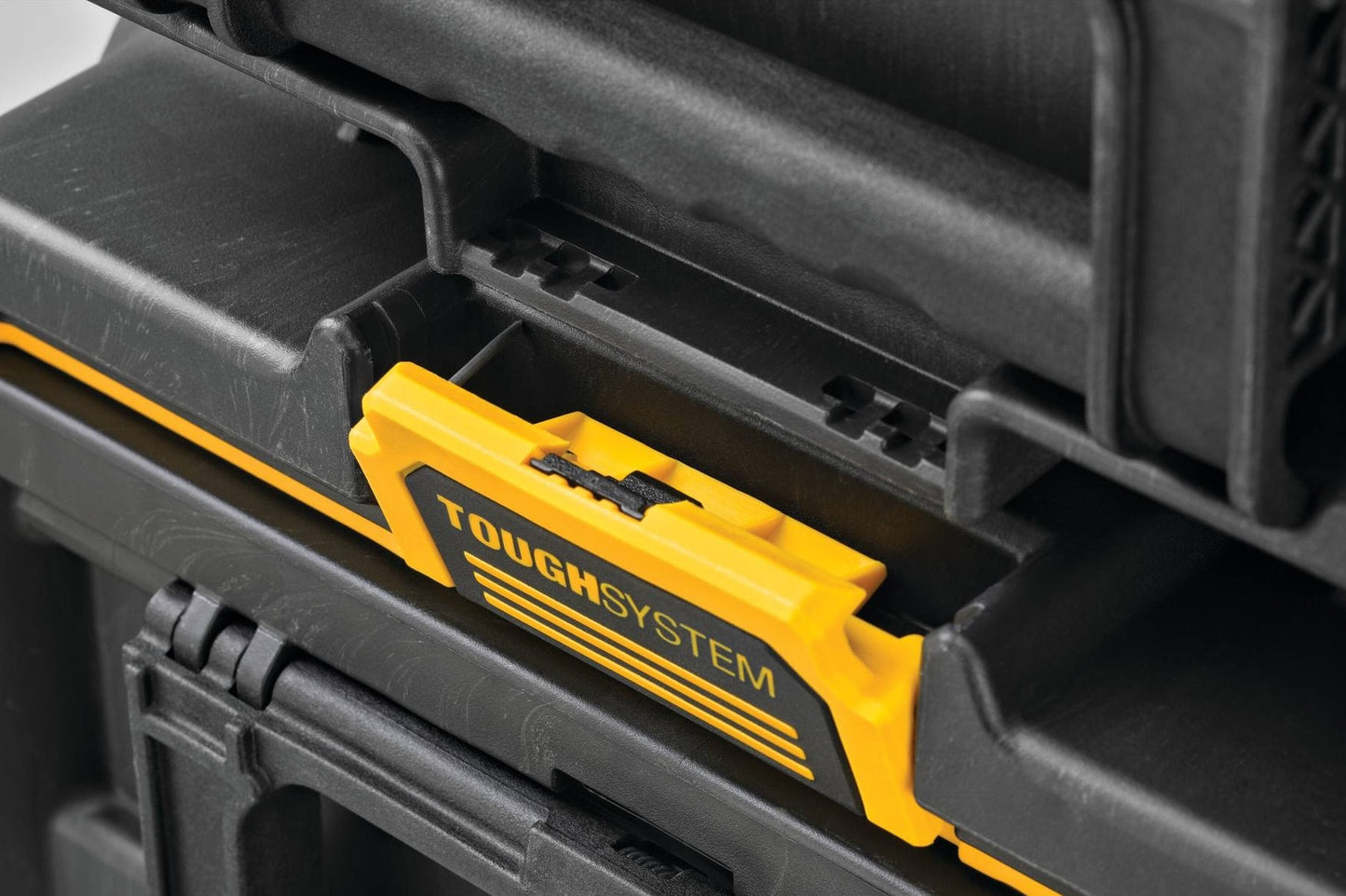 Close-up of a yellow and black ToughSystem latch on a durable toolbox for organized tool storage in home improvement projects