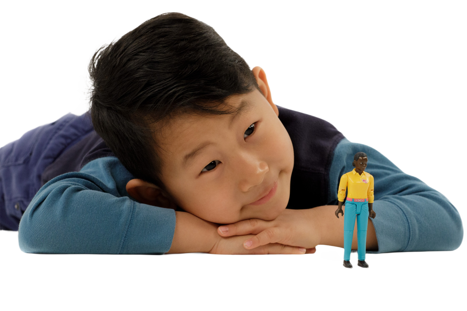 Child lying down resting head on hands next to Bruder Woman with Dark Skin & Turquoise Jeans Action Figure from Toys & Games