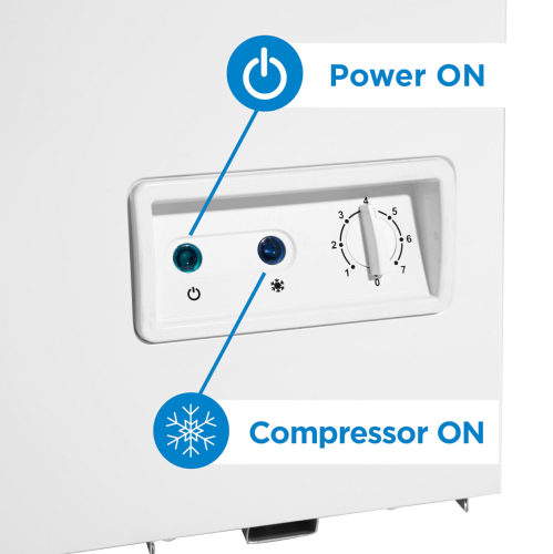 Close-up of white chest freezer control panel showing power and compressor indicator lights with temperature dial