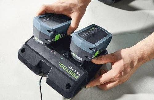 Dual rapid battery charger station with ergonomic grip inserting two batteries for tools and home improvement use