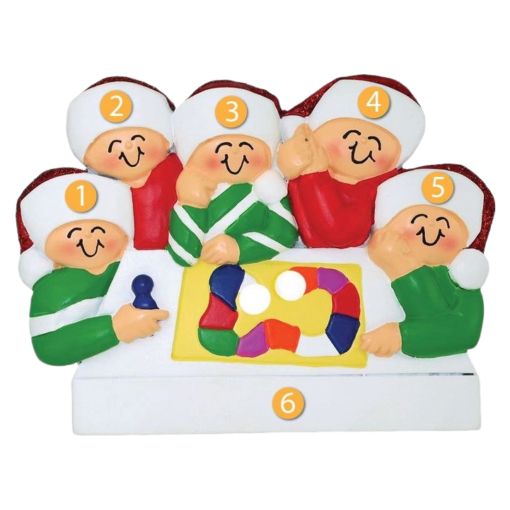 Festive ornament depicting five smiling figures in holiday hats gathered around a colorful family game board scene
