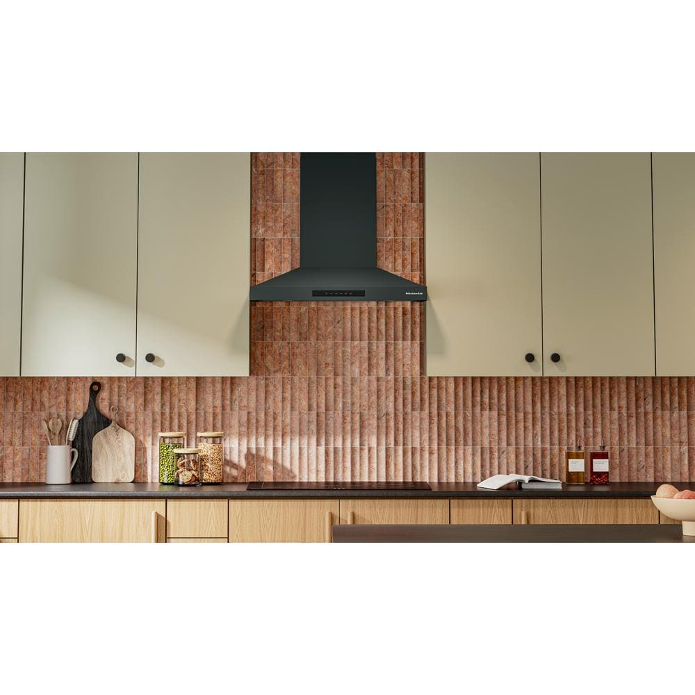 Matte black wall-mount canopy hood with four-speed fan and power-boost function in modern kitchen setting