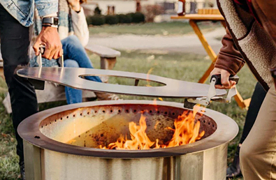 Hot-rolled carbon steel griddle with handles lifting onto fire pit for outdoor living and patio furniture collections