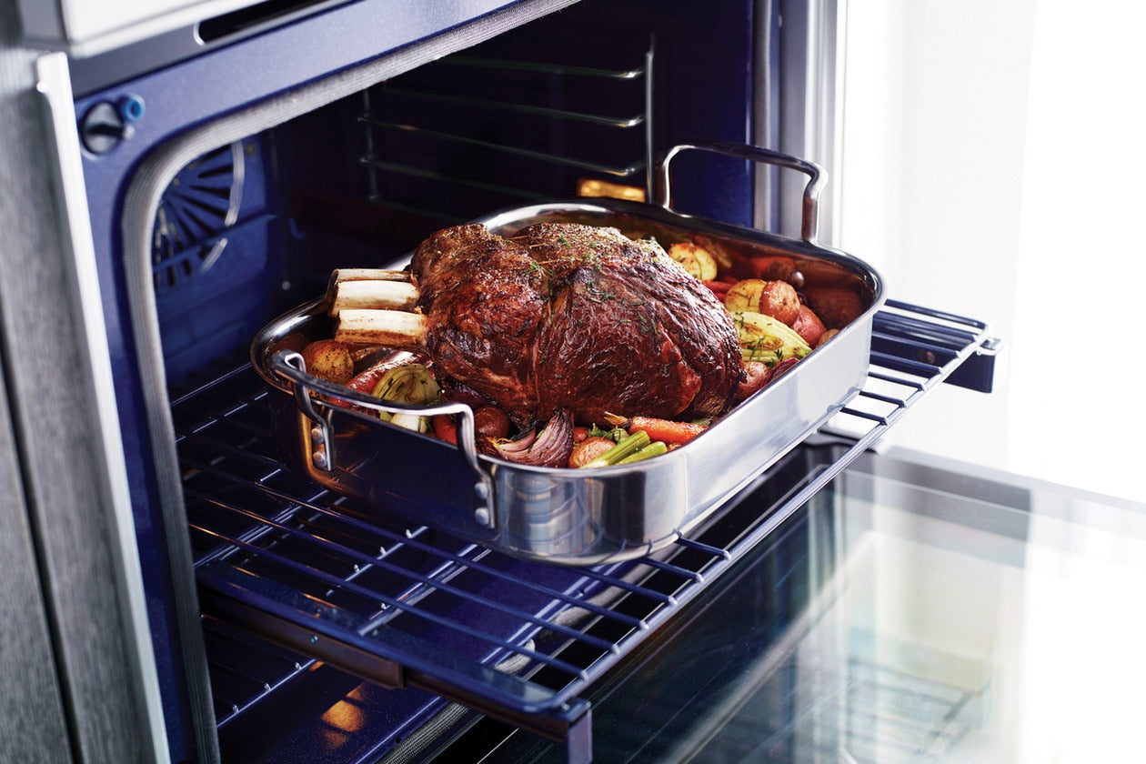 Oven interior with a roast and vegetables cooking on a Luxury-Glide® rack in a modern double wall oven from Kitchen & Kitchenware collection